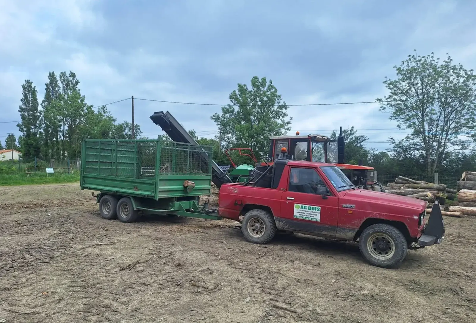 Pick-up AG Bois tractant une remorque de bois, avec un tracteur équipé d'une grue